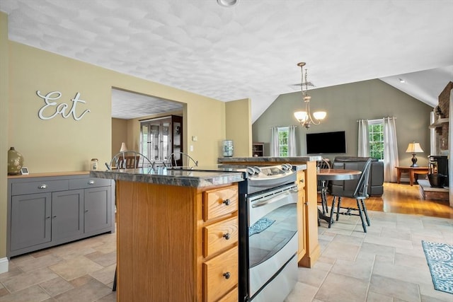 15 Hillside St, Rowley, MA 01969 - kitchen featuring stainless steel stove, vaulted ceiling, gray cabinetry, a kitchen island, and light stone finish floors