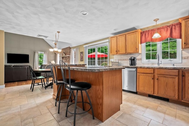 15 Hillside St, Rowley, MA 01969 - kitchen with stainless steel dishwasher, a kitchen island, a chandelier, lofted ceiling, and a kitchen breakfast bar