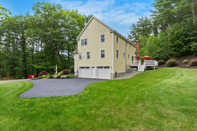 15 Hillside St, Rowley, MA 01969 - view of property exterior with asphalt driveway, an attached garage, a wooden deck, and a lawn