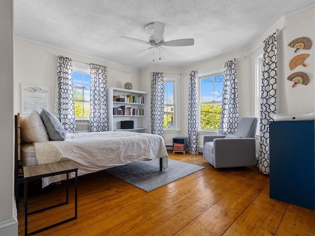 5 Tremont St Unit 3, Cambridge, MA 02139 - bedroom featuring hardwood / wood-style floors, crown molding, a textured ceiling, ceiling fan, and a baseboard heating unit