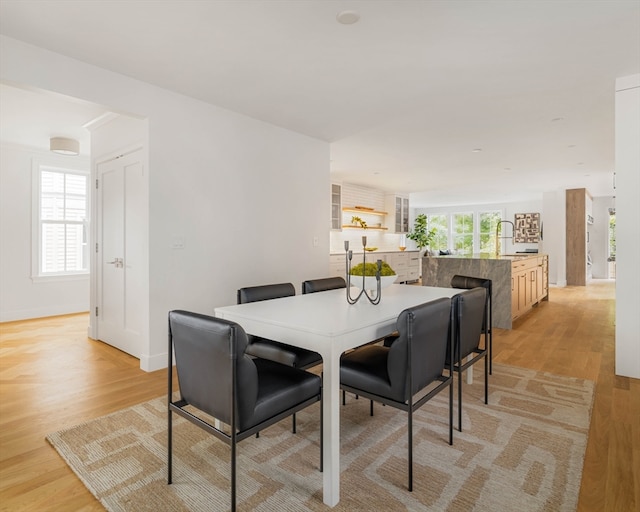 dining space with light hardwood / wood-style floors and sink