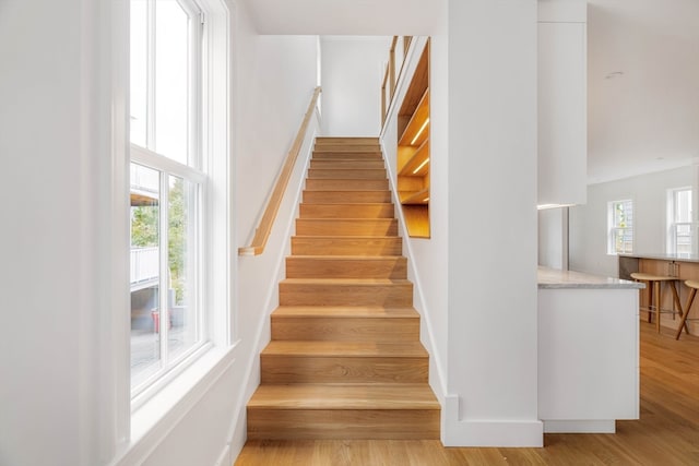 stairway with hardwood / wood-style flooring and a healthy amount of sunlight