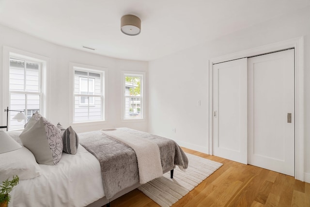 bedroom featuring wood-type flooring and a closet