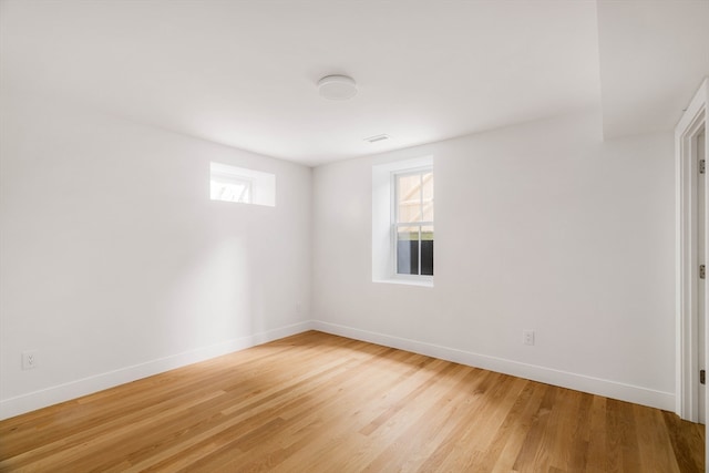 empty room with light hardwood / wood-style flooring and a wealth of natural light