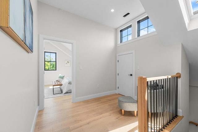 foyer entrance with light hardwood / wood-style floors and vaulted ceiling