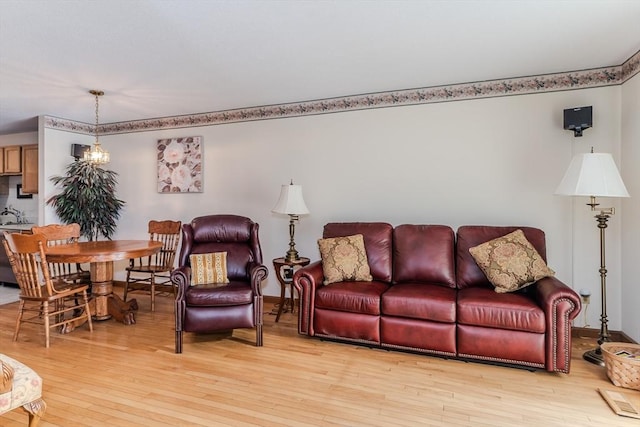 living room with a notable chandelier and light wood-type flooring