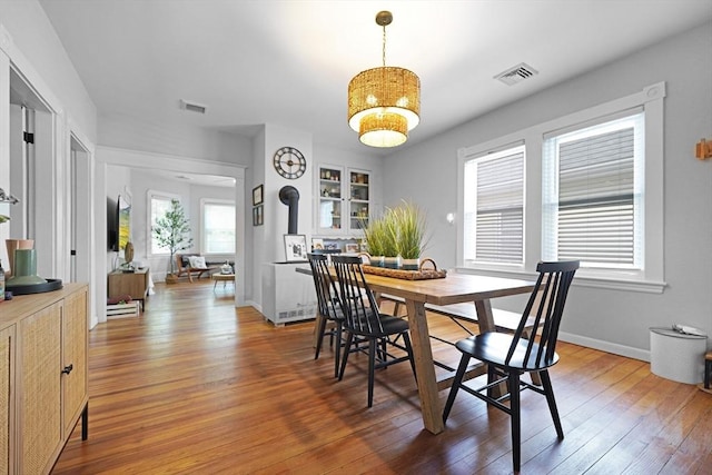 180 Irvington St, New Bedford, MA 02745 - dining space with hardwood / wood-style flooring, a wood stove, and baseboards