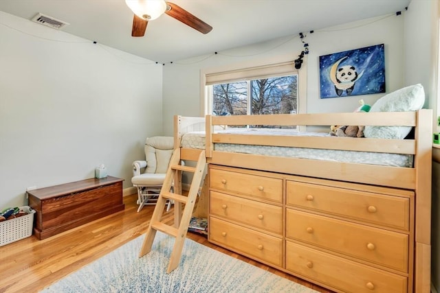 bedroom with visible vents, wood finished floors, and a ceiling fan