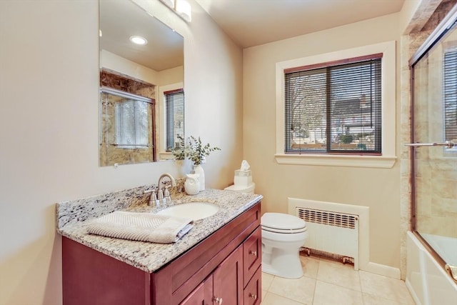 bathroom with baseboards, toilet, radiator heating unit, tile patterned floors, and vanity