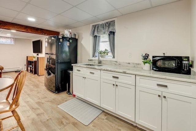 kitchen featuring black appliances, a baseboard heating unit, light wood-type flooring, white cabinetry, and a sink