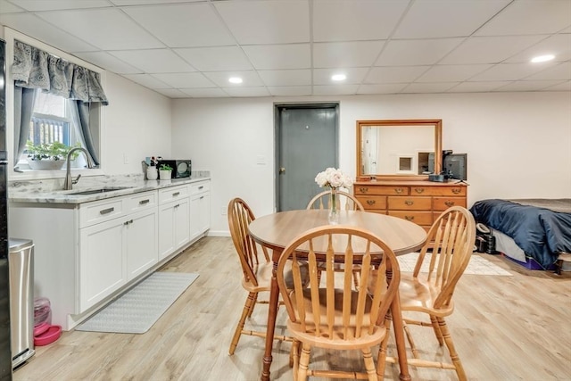 dining area with recessed lighting, a paneled ceiling, light wood-type flooring, and baseboards