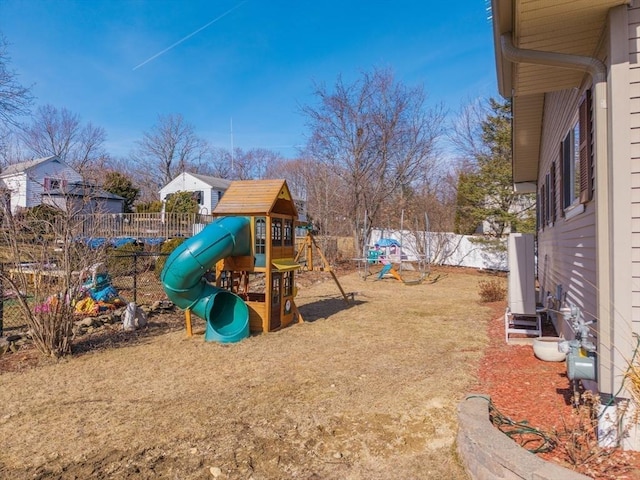 view of jungle gym with a lawn and fence