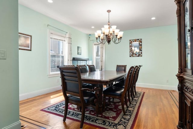 dining area with an inviting chandelier, baseboards, recessed lighting, and light wood-type flooring