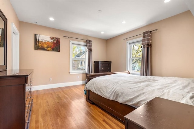 bedroom with recessed lighting, baseboards, multiple windows, and light wood-type flooring