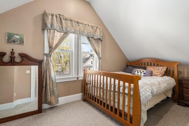 carpeted bedroom with baseboards and vaulted ceiling