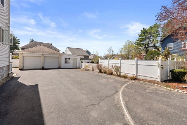 exterior space with a detached garage and fence