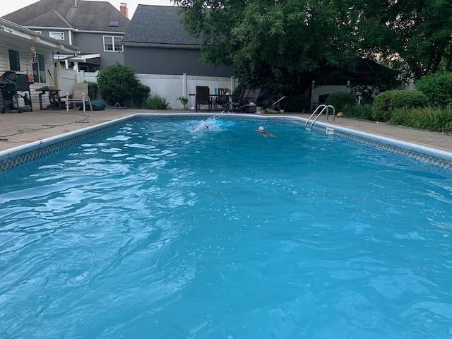 view of swimming pool with a fenced in pool, fence, and a patio