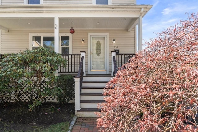 view of exterior entry featuring covered porch