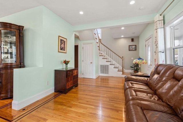 living room with visible vents, stairway, baseboards, light wood finished floors, and recessed lighting