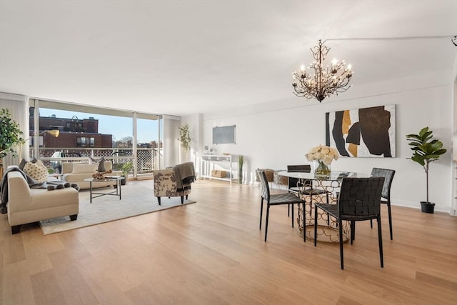 dining space featuring an inviting chandelier, light hardwood / wood-style flooring, and expansive windows