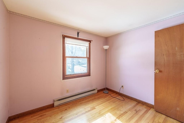 empty room with light wood-type flooring, baseboards, and a baseboard heating unit