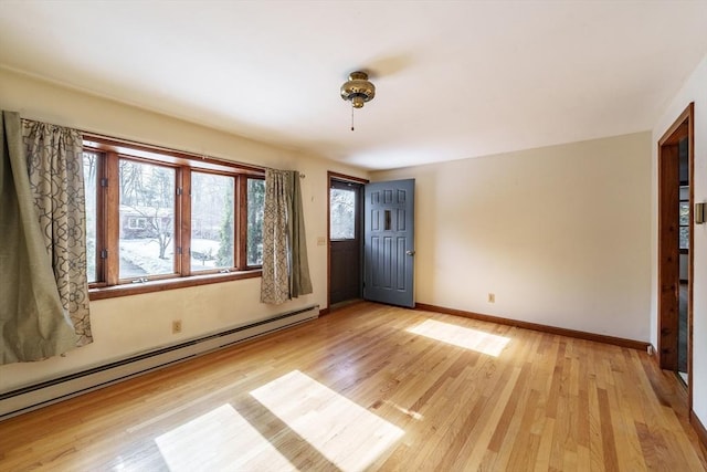 entrance foyer featuring light wood finished floors, baseboard heating, and baseboards