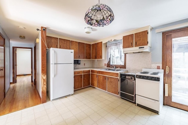 kitchen featuring under cabinet range hood, white appliances, a sink, light countertops, and light floors