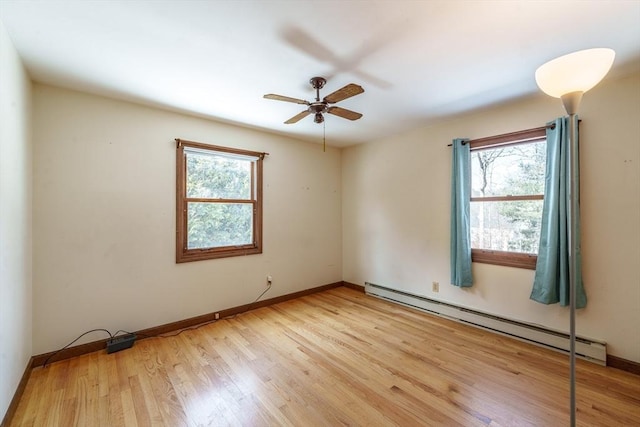 empty room featuring light wood-style floors, a baseboard radiator, baseboards, and a ceiling fan