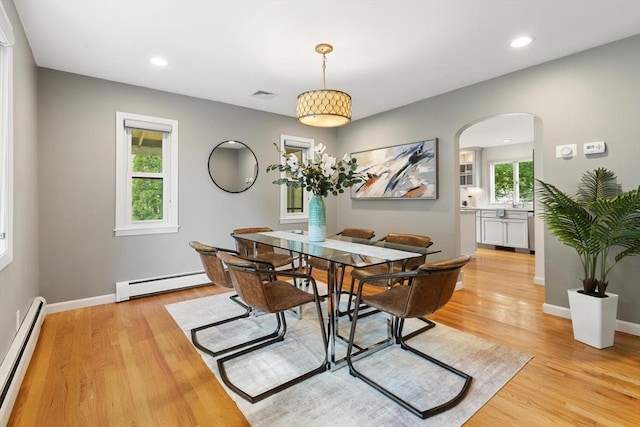 11 Williams St, Arlington, MA 02476 - dining space with a baseboard heating unit, arched walkways, light wood finished floors, and recessed lighting
