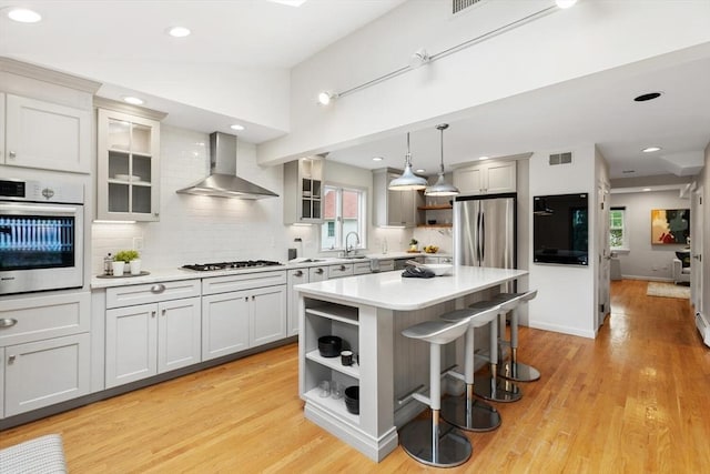 11 Williams St, Arlington, MA 02476 - kitchen with appliances with stainless steel finishes, wall chimney range hood, open shelves, light countertops, and recessed lighting