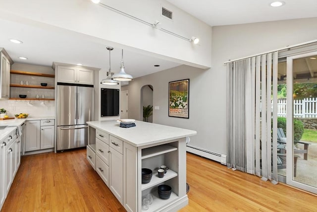 11 Williams St, Arlington, MA 02476 - kitchen with open shelves, stainless steel fridge, a baseboard radiator, arched walkways, and pendant lighting