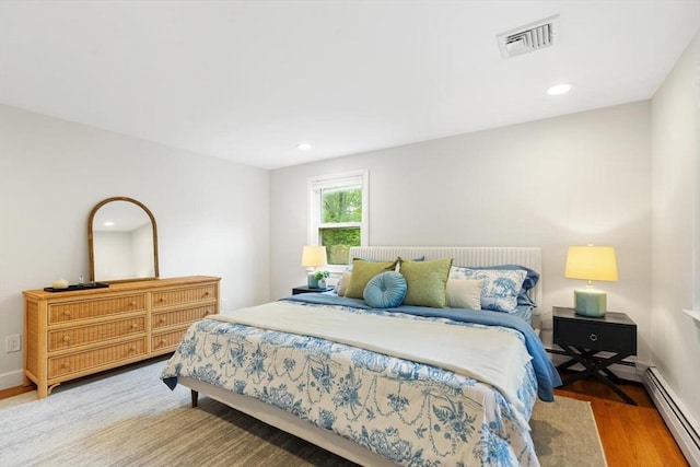 11 Williams St, Arlington, MA 02476 - bedroom featuring a baseboard heating unit, light wood-style flooring, and recessed lighting
