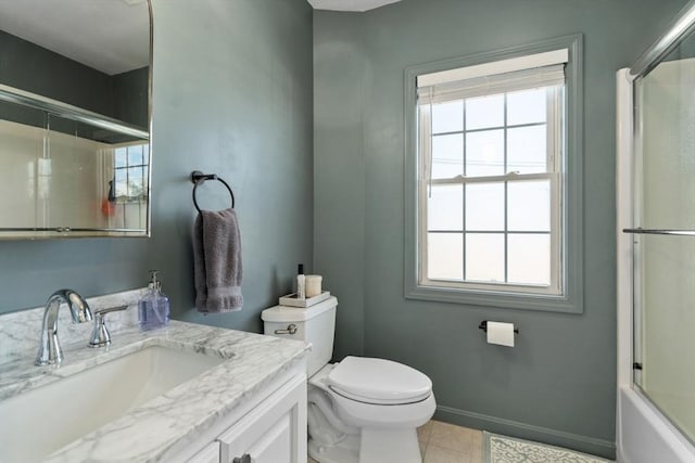 bathroom featuring a healthy amount of sunlight, toilet, vanity, and baseboards