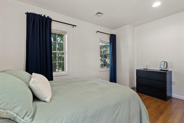 bedroom featuring recessed lighting, wood finished floors, visible vents, and baseboards