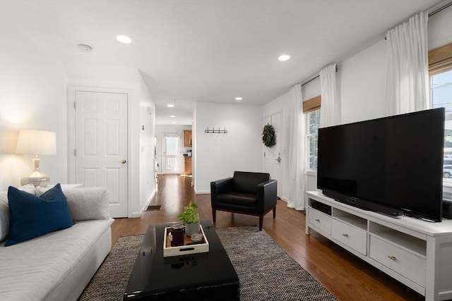 living area featuring plenty of natural light, recessed lighting, dark wood-type flooring, and baseboards