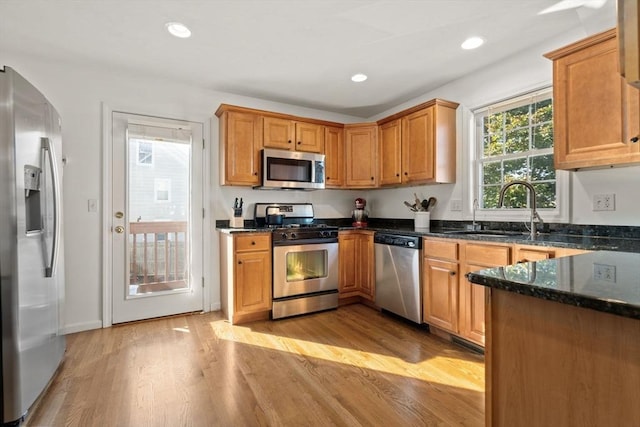 kitchen featuring light wood finished floors, recessed lighting, appliances with stainless steel finishes, and a sink