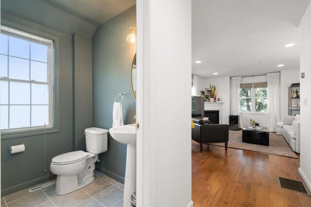 bathroom with recessed lighting, visible vents, toilet, and a fireplace