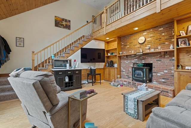 161 Old Farm Rd, Leominster, MA 01453 - living room featuring stairway, a wood stove, wood finished floors, and high vaulted ceiling