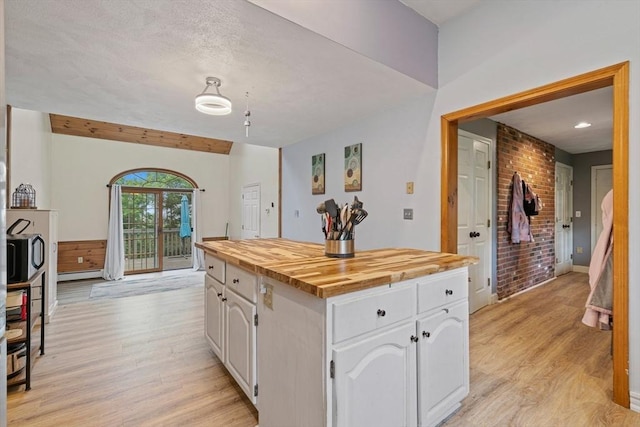 161 Old Farm Rd, Leominster, MA 01453 - kitchen with light wood-type flooring, wood counters, white cabinetry, baseboard heating, and a kitchen island
