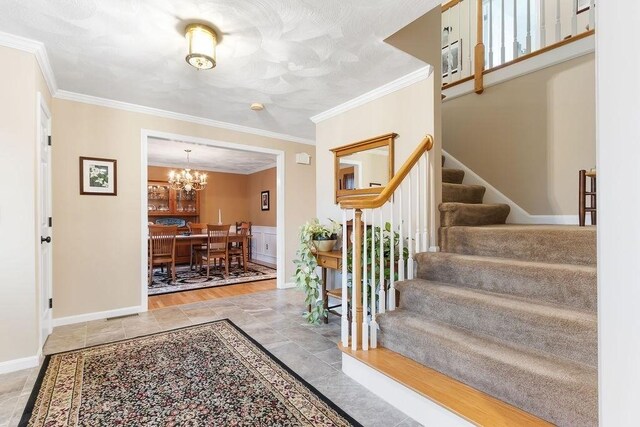 19 Miele Rd, Marlborough, MA 01752 - entryway featuring crown molding, stairs, a chandelier, and baseboards