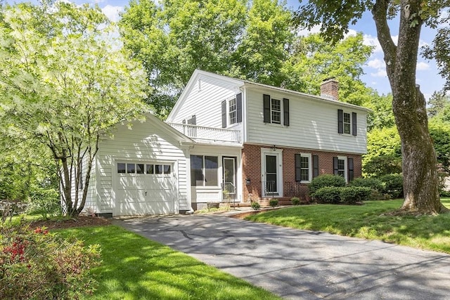 79 Cheever Cir, Andover, MA 01810 - colonial home featuring a chimney, an attached garage, brick siding, driveway, and a front lawn