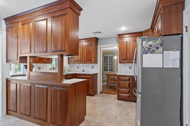 79 Cheever Cir, Andover, MA 01810 - kitchen with freestanding refrigerator, a peninsula, brown cabinetry, a sink, and recessed lighting