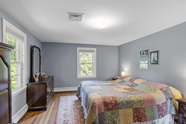 79 Cheever Cir, Andover, MA 01810 - bedroom featuring a baseboard heating unit, wood finished floors, multiple windows, and baseboards