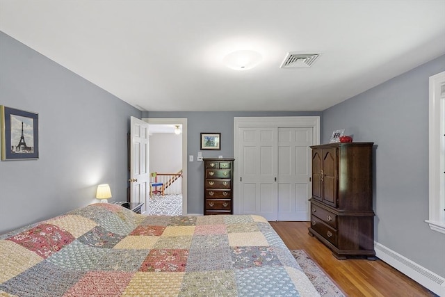 79 Cheever Cir, Andover, MA 01810 - bedroom featuring wood finished floors, a closet, baseboard heating, and baseboards