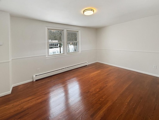 empty room with baseboards, a baseboard heating unit, and wood finished floors