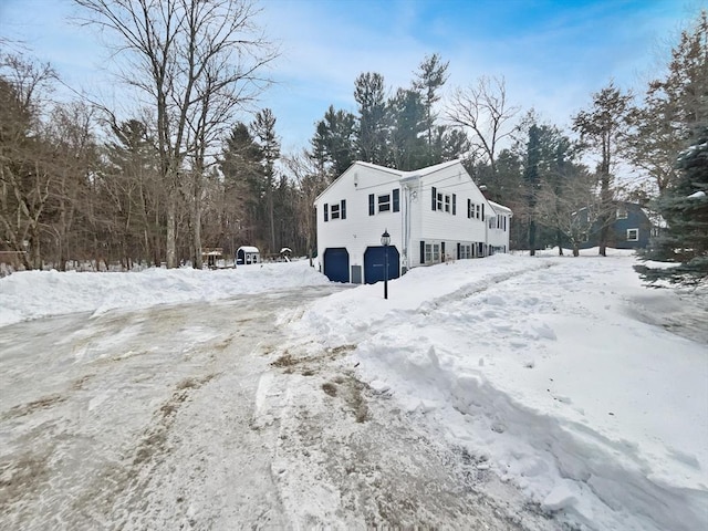 view of snowy exterior featuring a garage