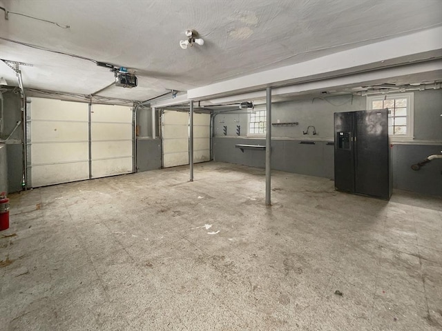 parking garage featuring black fridge and a garage door opener