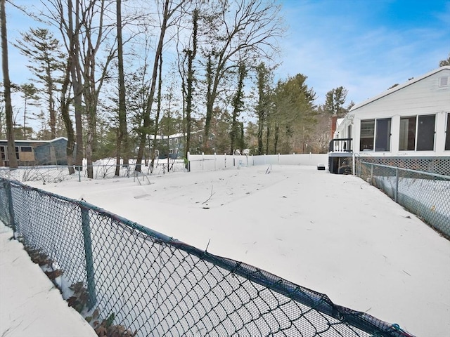 snowy yard with a fenced backyard