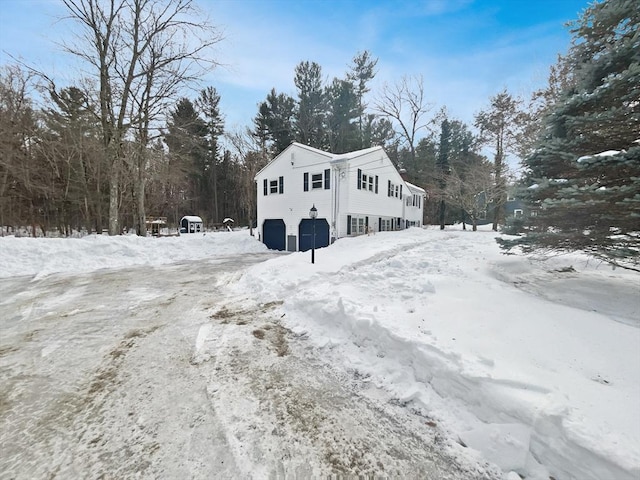 snow covered property with a garage