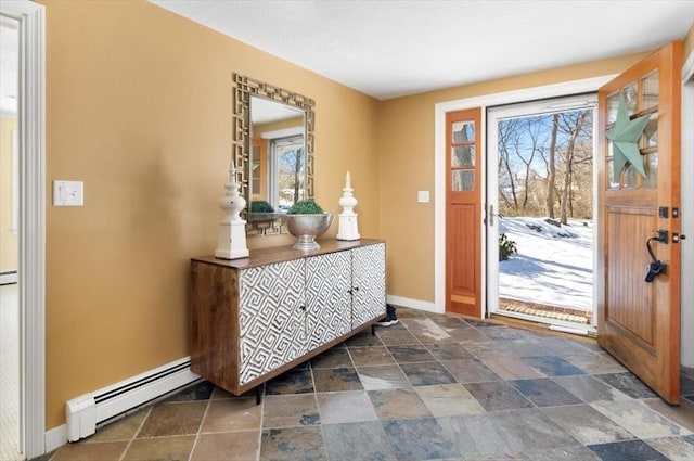 doorway to outside with stone finish floor, baseboards, and baseboard heating